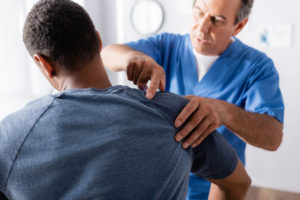 physical therapist evaluating patient's shoulder and arm