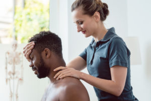 Sports Therapists Baltimore, MD - Woman physical therapist massaging young man